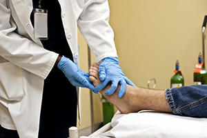 Chiropodist Checking The Bottom Of A Patient's Foot