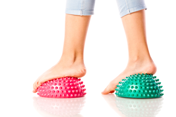 A girl balancing on soft-spike massage balls